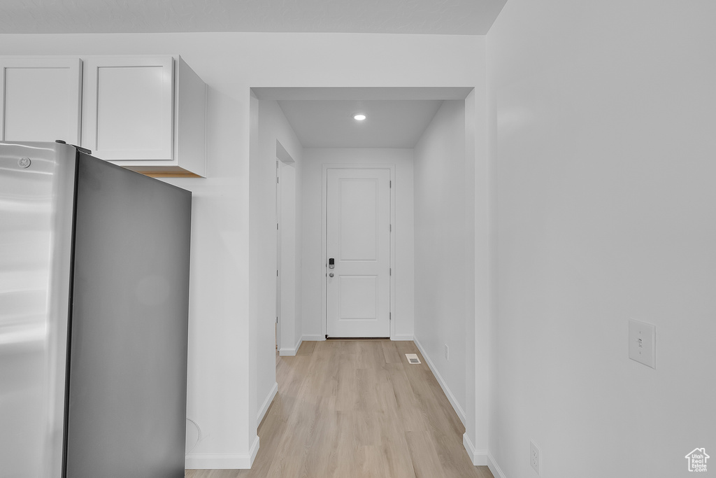 Corridor with light wood-type flooring, baseboards, and recessed lighting
