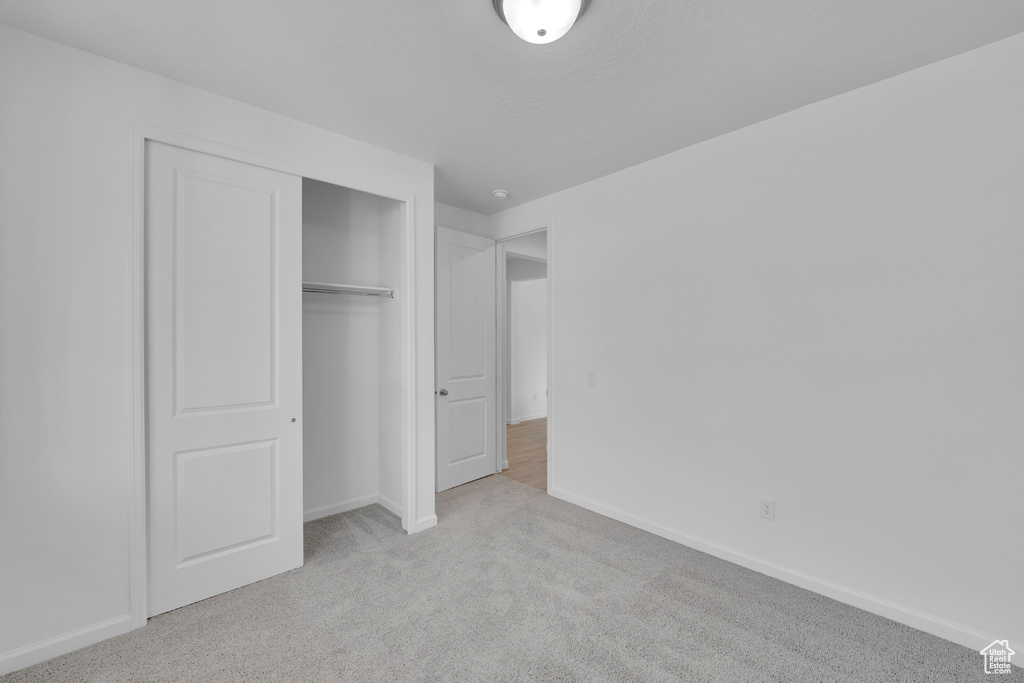 Unfurnished bedroom with carpet, baseboards, and a closet