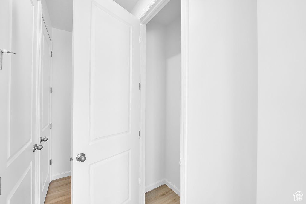 Hallway featuring light wood-type flooring and baseboards
