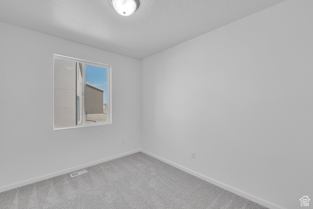 Carpeted empty room featuring baseboards
