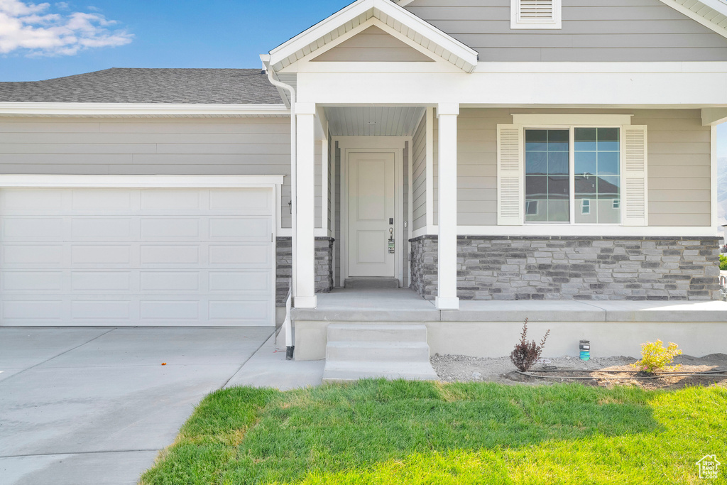 View of front facade featuring concrete driveway, an attached garage, and stone siding