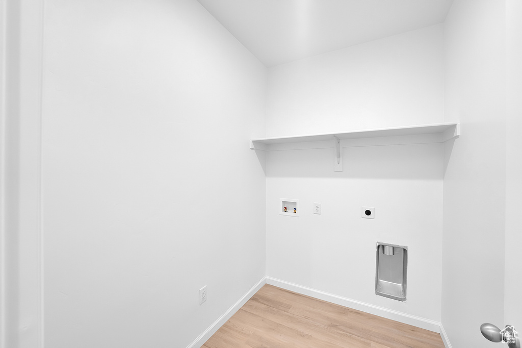 Washroom with hookup for a washing machine, light wood-style floors, baseboards, and hookup for an electric dryer