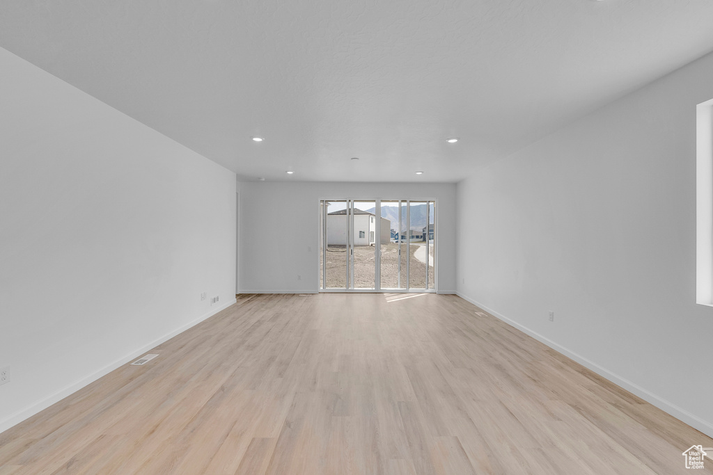 Spare room featuring light wood-style floors, baseboards, and recessed lighting