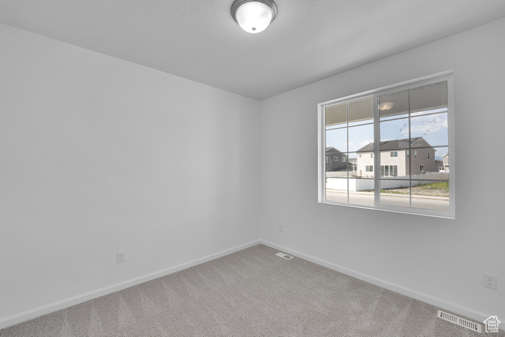 Carpeted empty room with baseboards
