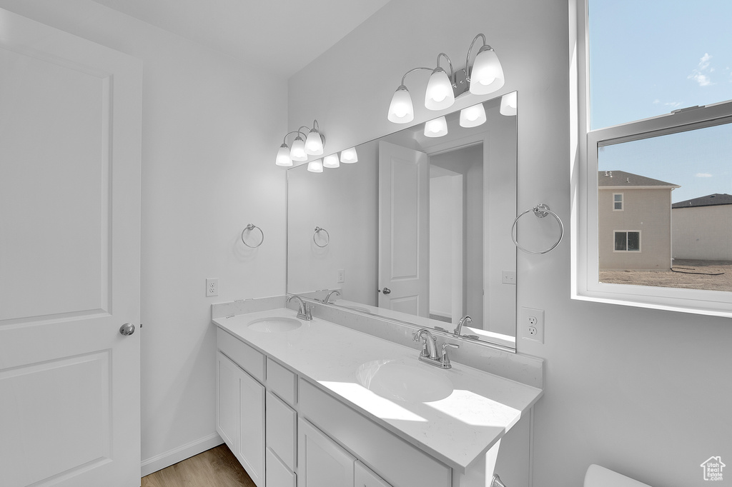 Bathroom featuring double vanity and wood finished floors