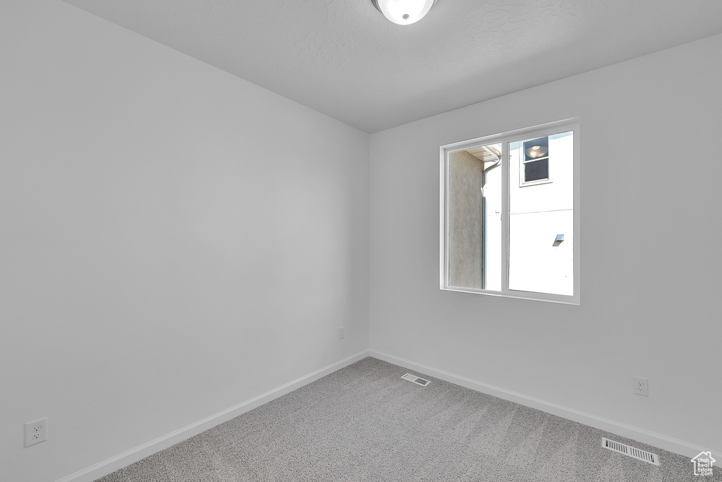 Carpeted empty room featuring baseboards