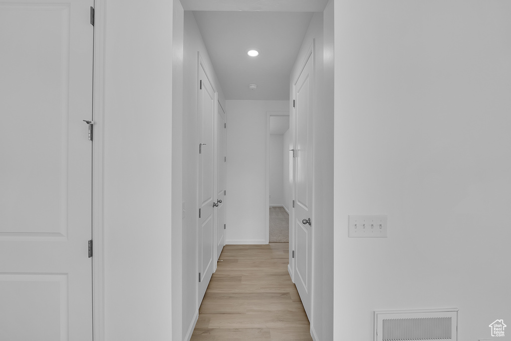 Hall with recessed lighting, light wood finished floors, and baseboards