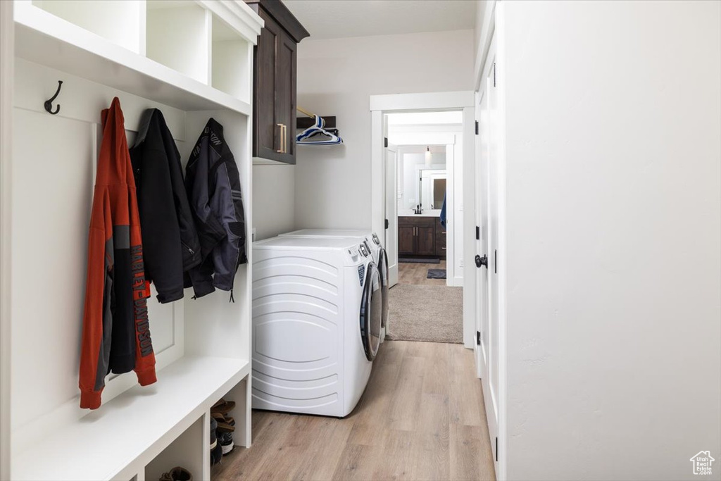 Mudroom featuring separate washer and dryer and light hardwood / wood-style flooring