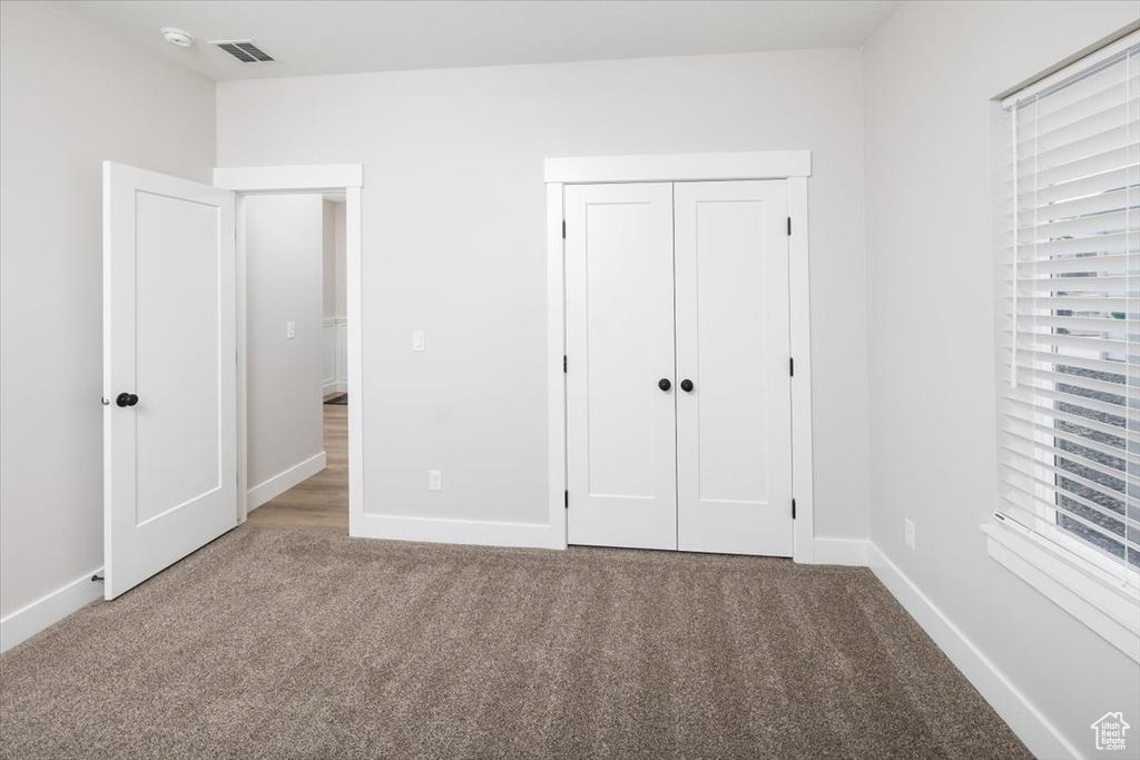 Unfurnished bedroom featuring a closet and carpet