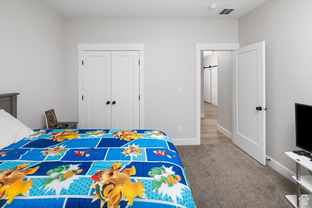 Carpeted bedroom with a closet