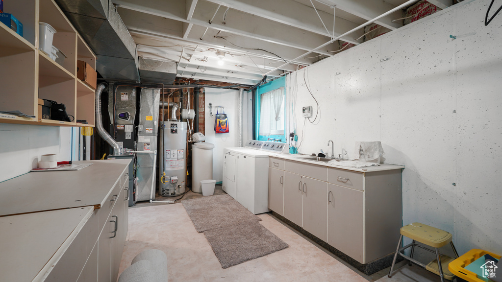 Below grade area featuring washer and dryer, water heater, a sink, and heating unit