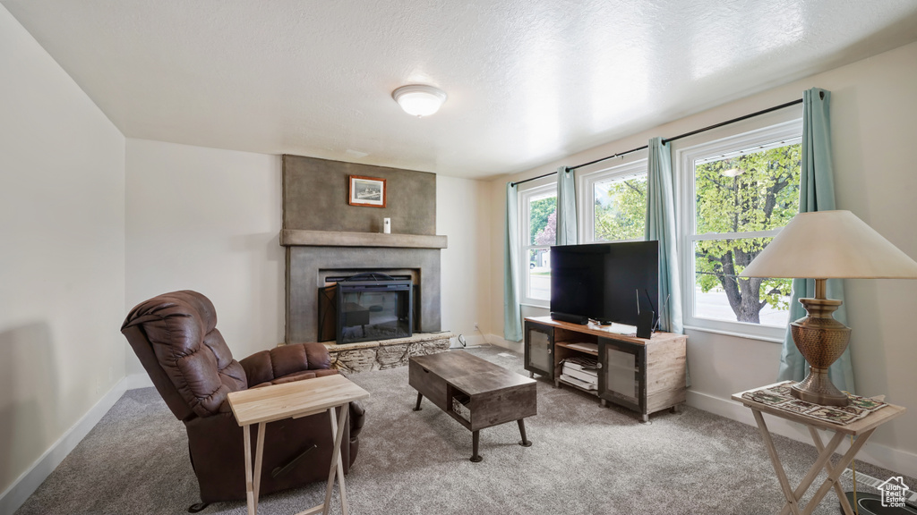 Living area with carpet flooring, a fireplace, and baseboards