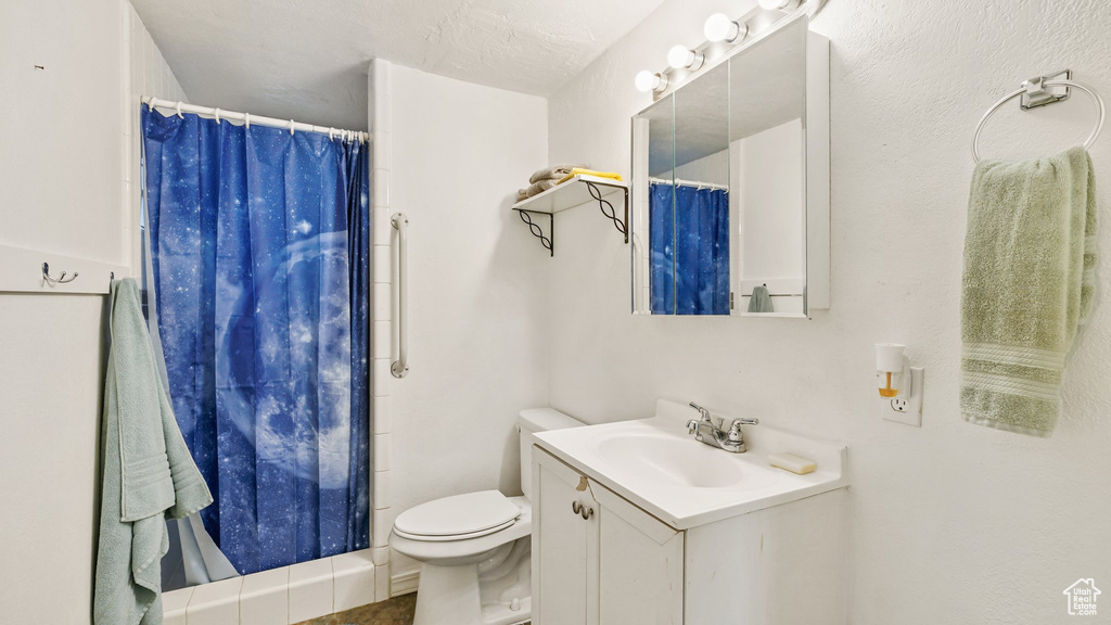 Bathroom with a textured ceiling, toilet, walk in shower, and vanity