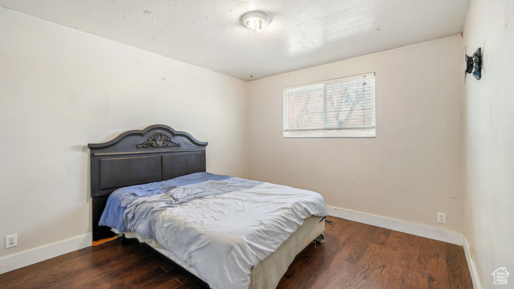 Bedroom with dark wood-type flooring
