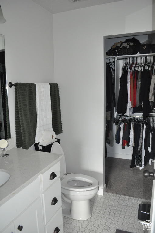 Bathroom featuring toilet, vanity, and tile patterned floors