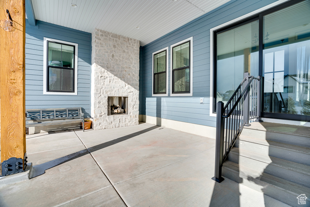 View of patio with an outdoor stone fireplace