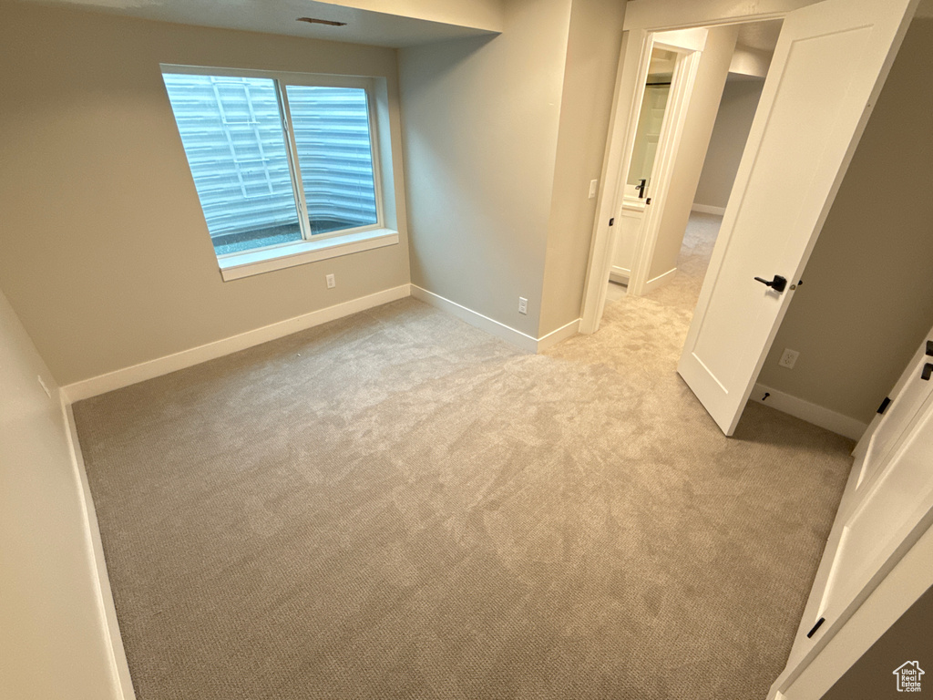 Unfurnished bedroom with light carpet