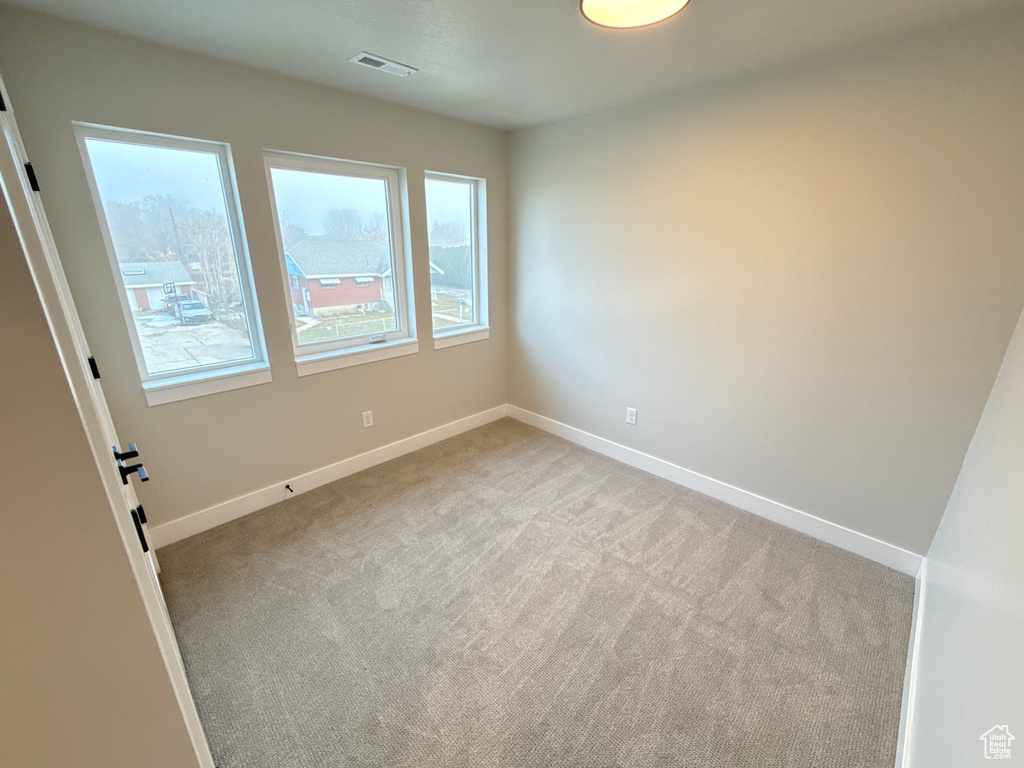 Empty room featuring a wealth of natural light and light colored carpet