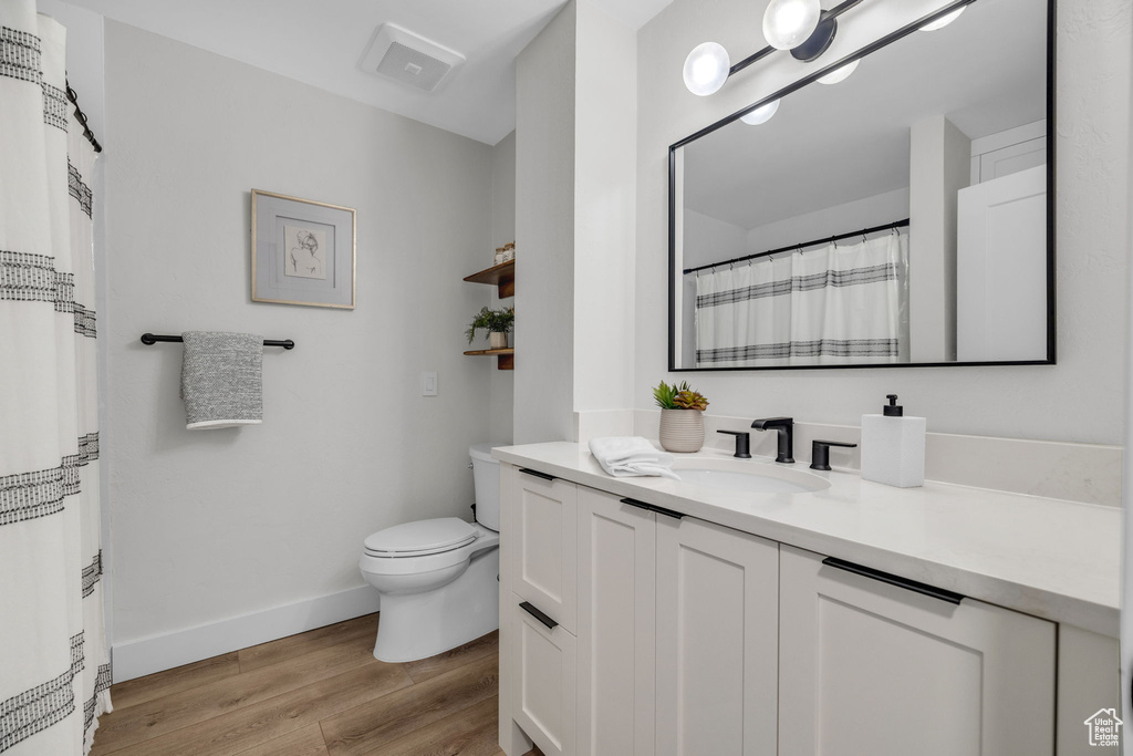 Bathroom featuring toilet, wood-type flooring, and vanity