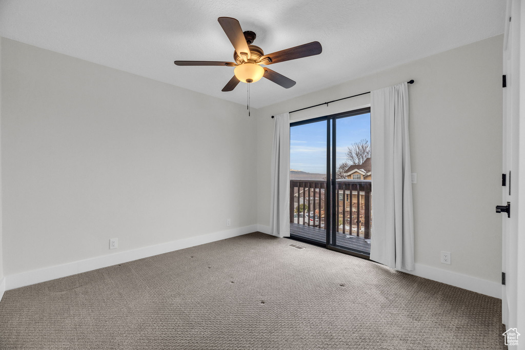 Carpeted spare room with ceiling fan