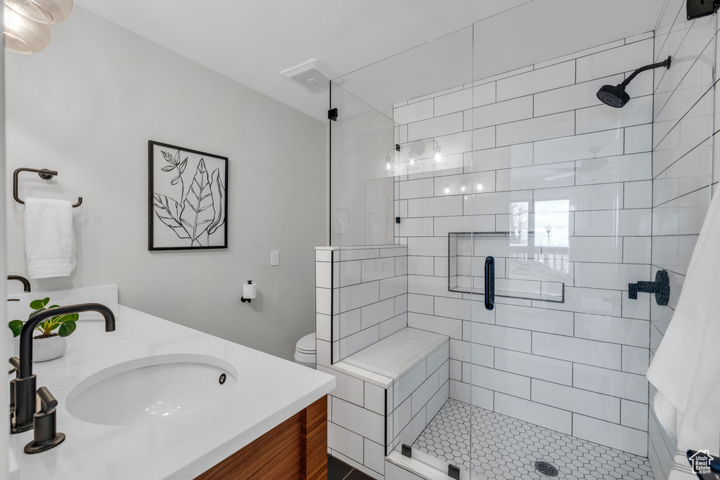 Bathroom with vanity, toilet, and walk in shower