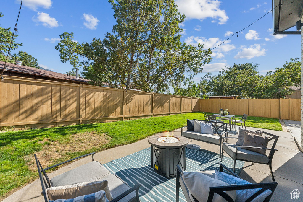 View of patio / terrace with an outdoor living space with a fire pit and a fenced backyard