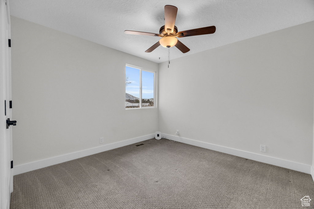 Carpeted spare room with ceiling fan