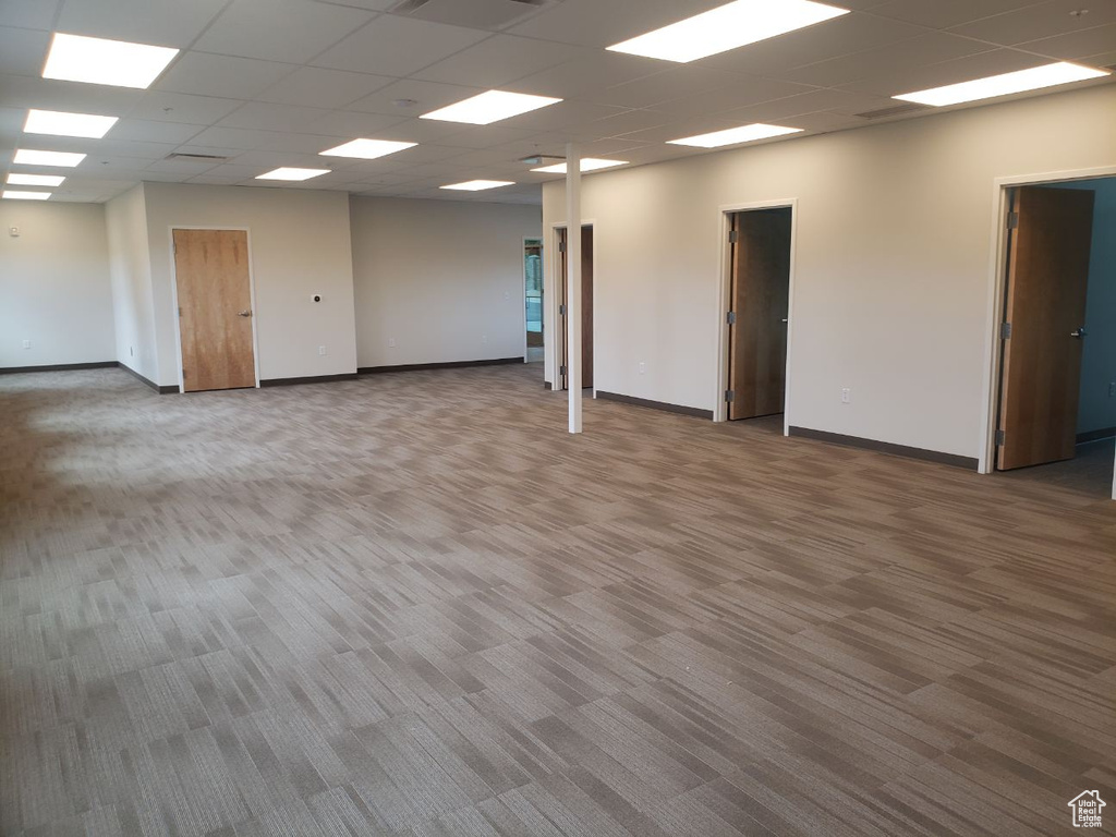 Carpeted empty room featuring a paneled ceiling