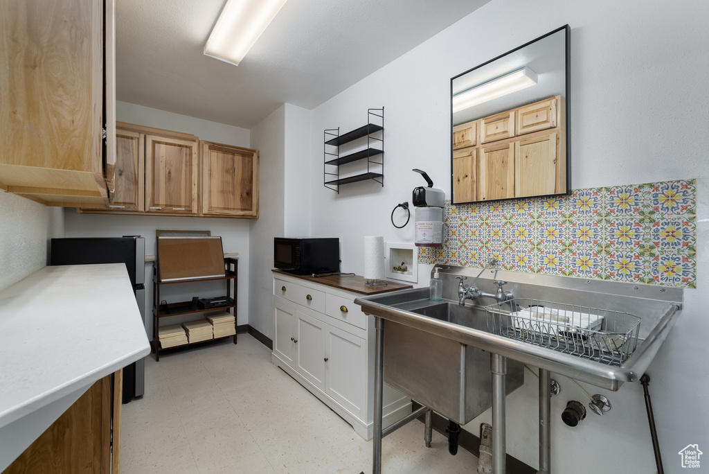 Kitchen with decorative backsplash and white cabinetry