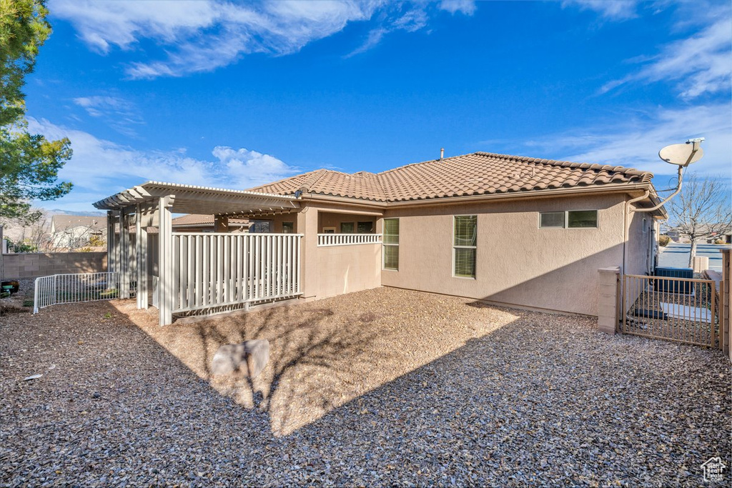 Rear view of property with a pergola