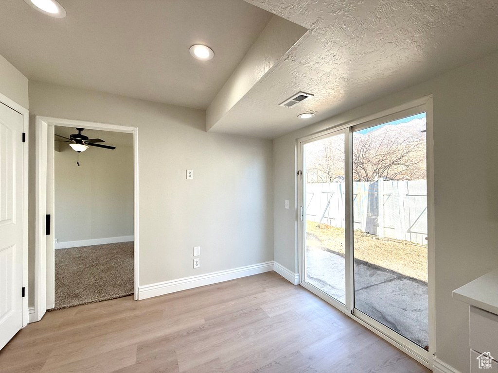 Interior space featuring a textured ceiling and light hardwood / wood-style floors