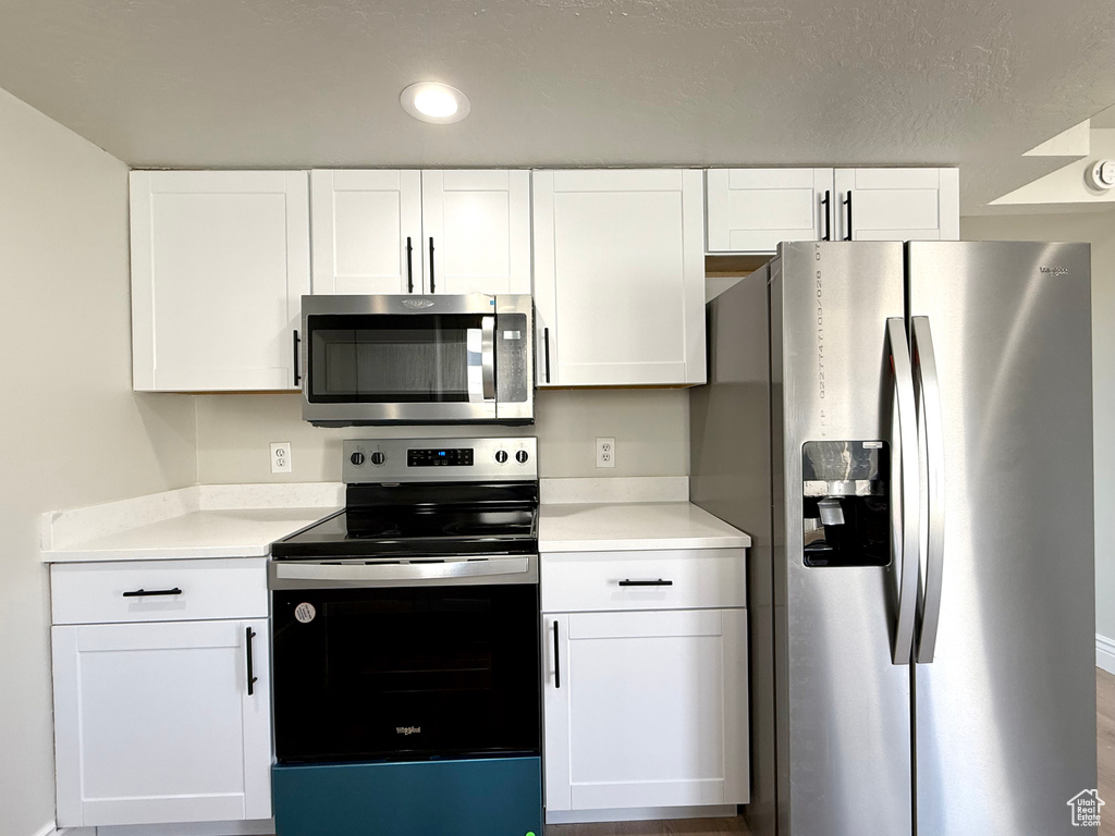 Kitchen featuring stainless steel appliances and white cabinets