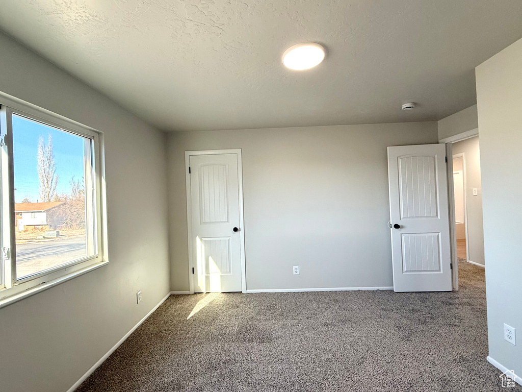 Unfurnished bedroom with carpet and a textured ceiling