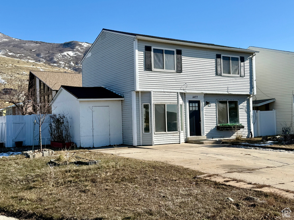 Rear view of house featuring a mountain view and a patio