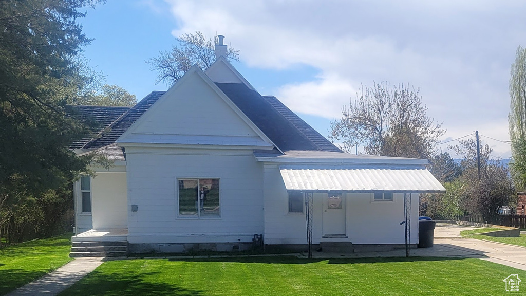 Back of house with a lawn
