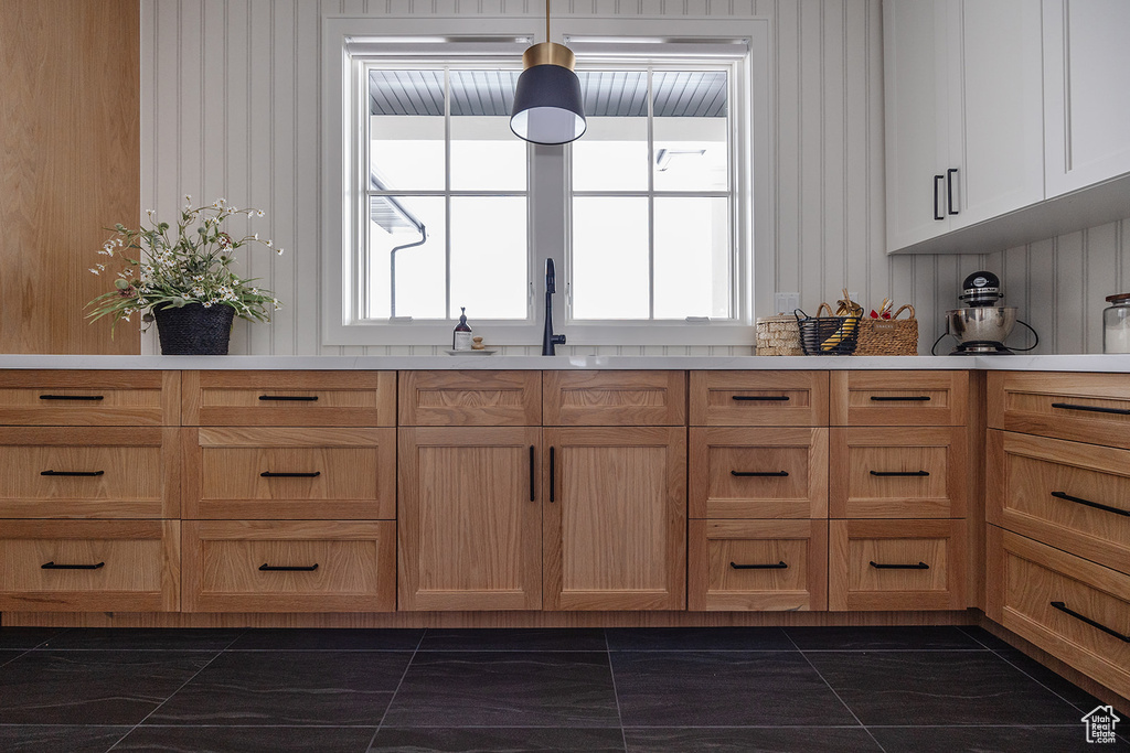 Kitchen featuring dark marble finish flooring, plenty of natural light, and light countertops