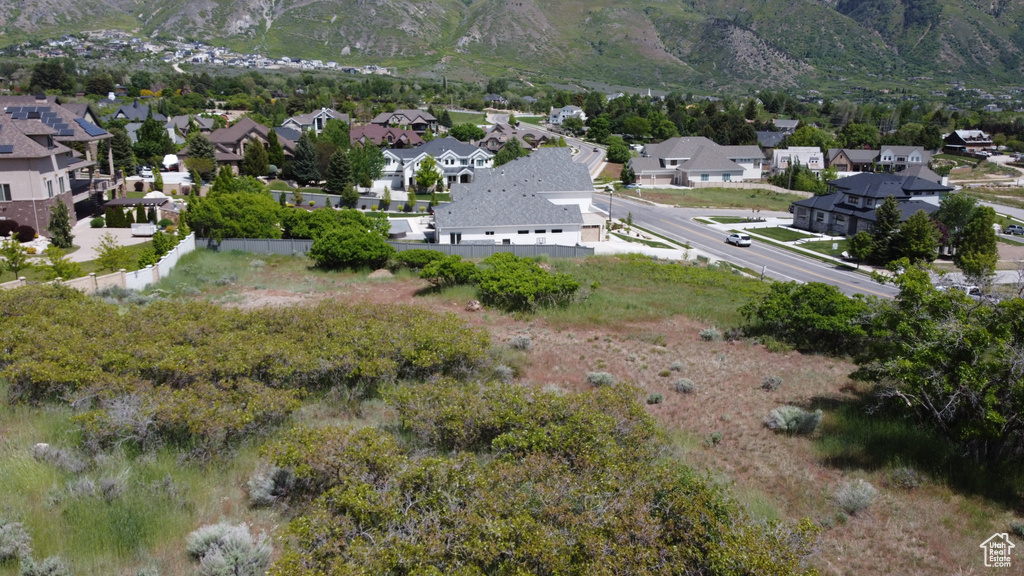 Aerial overview of property\'s location featuring nearby suburban area and a mountainous background