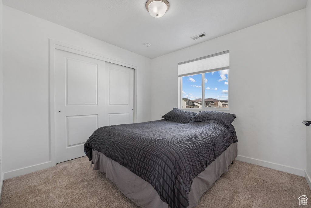 Carpeted bedroom featuring a closet