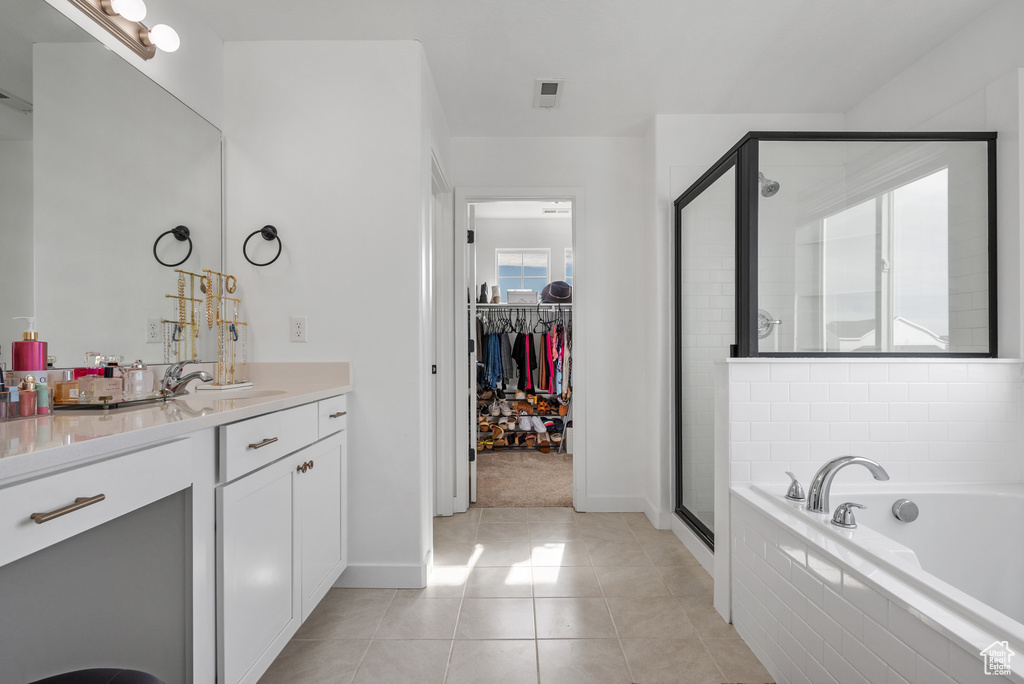 Bathroom featuring tile patterned flooring, plus walk in shower, and vanity