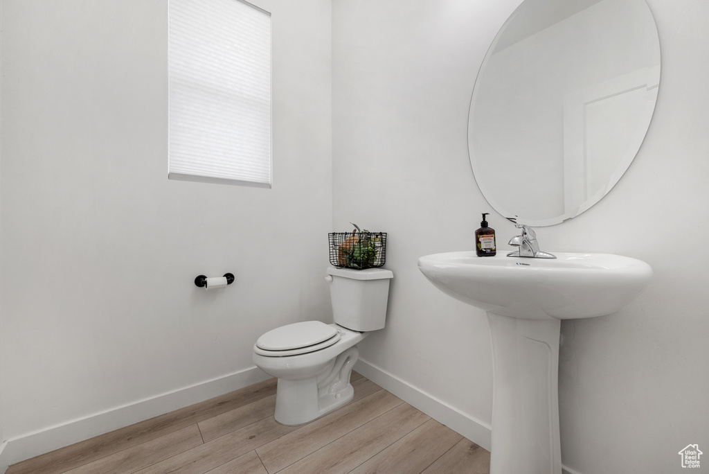 Bathroom with sink, wood-type flooring, and toilet