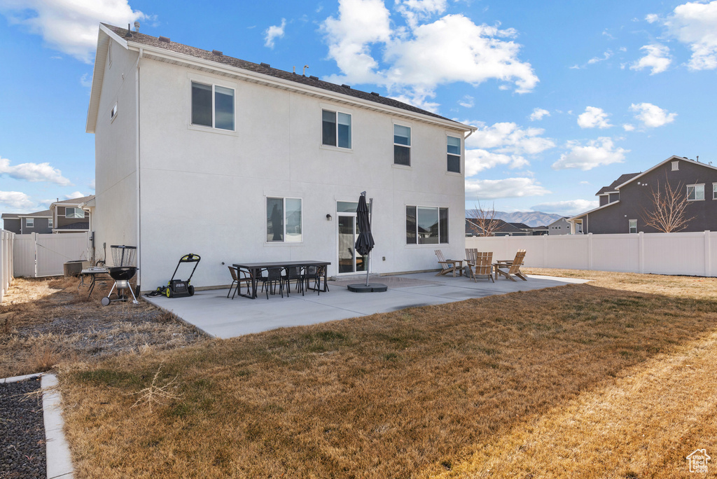 Back of property with a yard and a patio