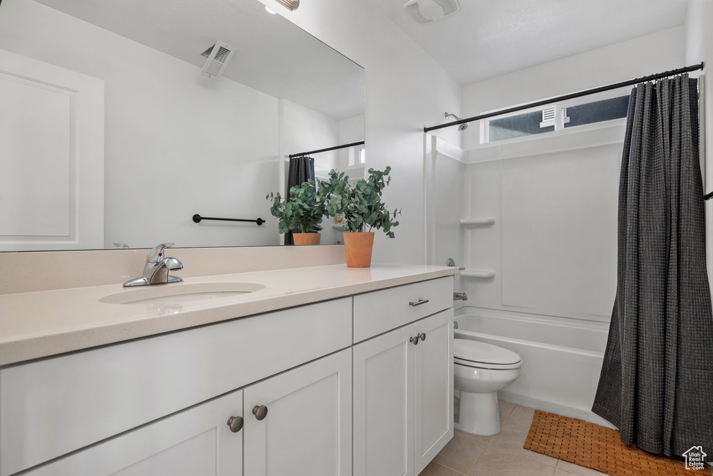 Full bathroom with shower / tub combo with curtain, vanity, toilet, and tile patterned flooring