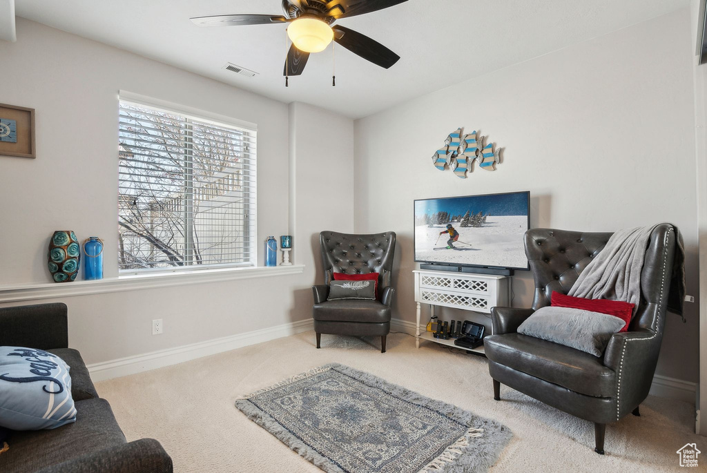 Living area featuring ceiling fan and carpet flooring