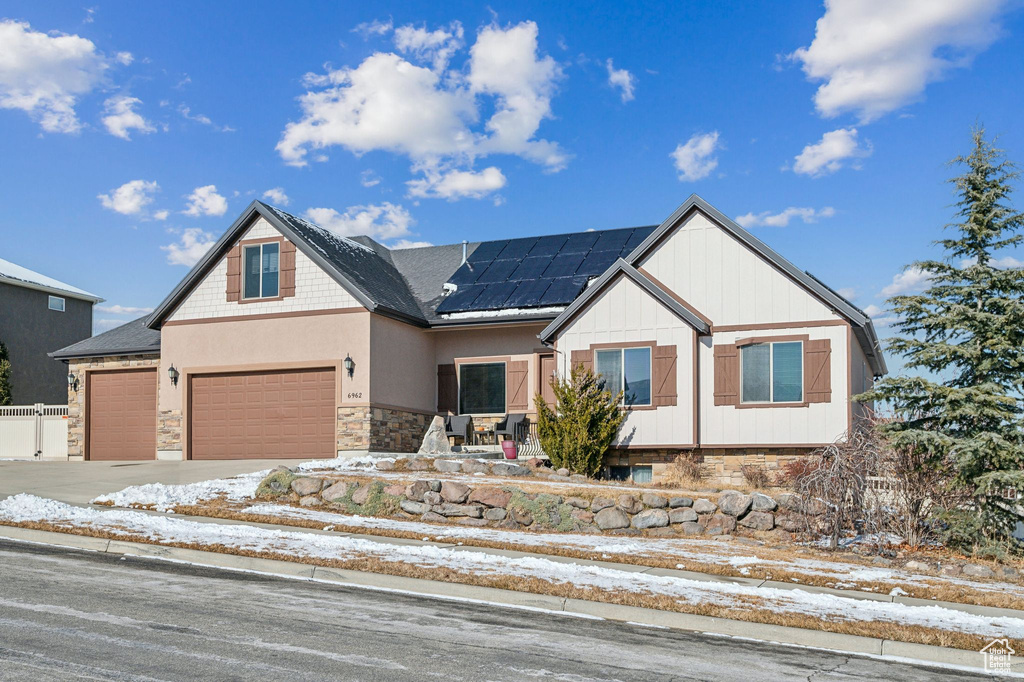 Craftsman-style house featuring a garage and solar panels