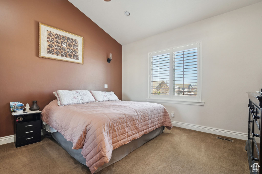 Carpeted bedroom with lofted ceiling