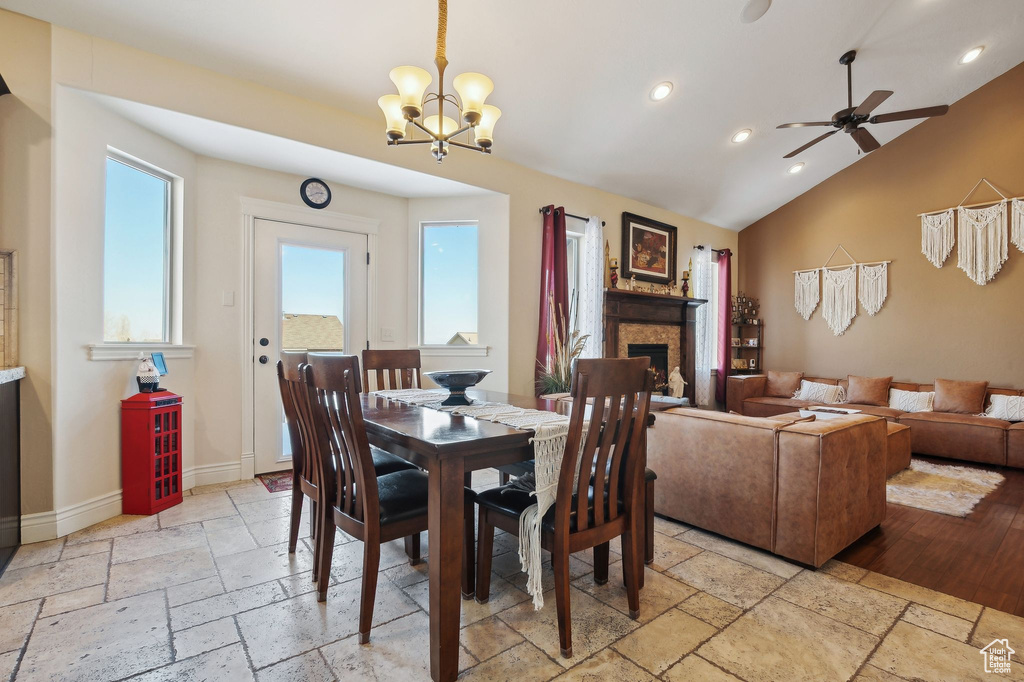 Dining space with ceiling fan with notable chandelier and vaulted ceiling