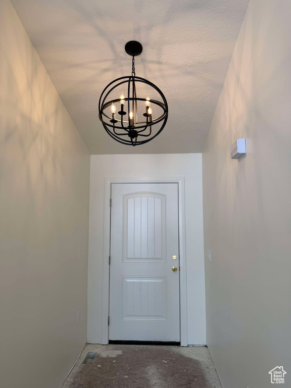 Entryway with an inviting chandelier and concrete floors