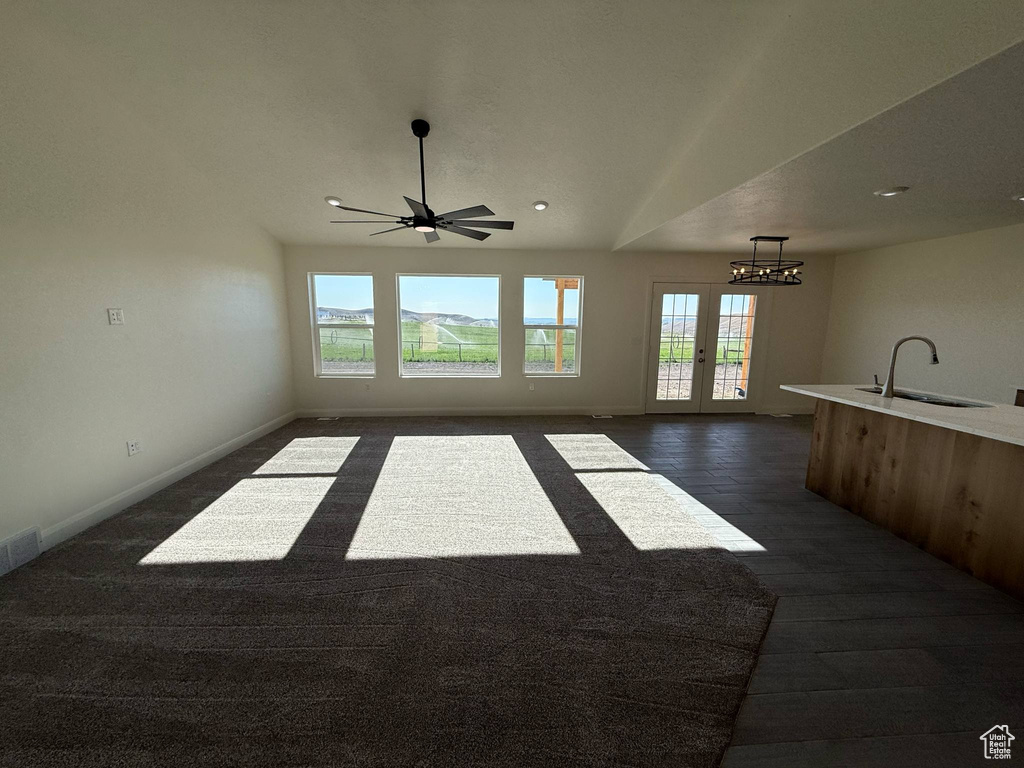 Unfurnished living room with a sink, healthy amount of natural light, baseboards, and recessed lighting