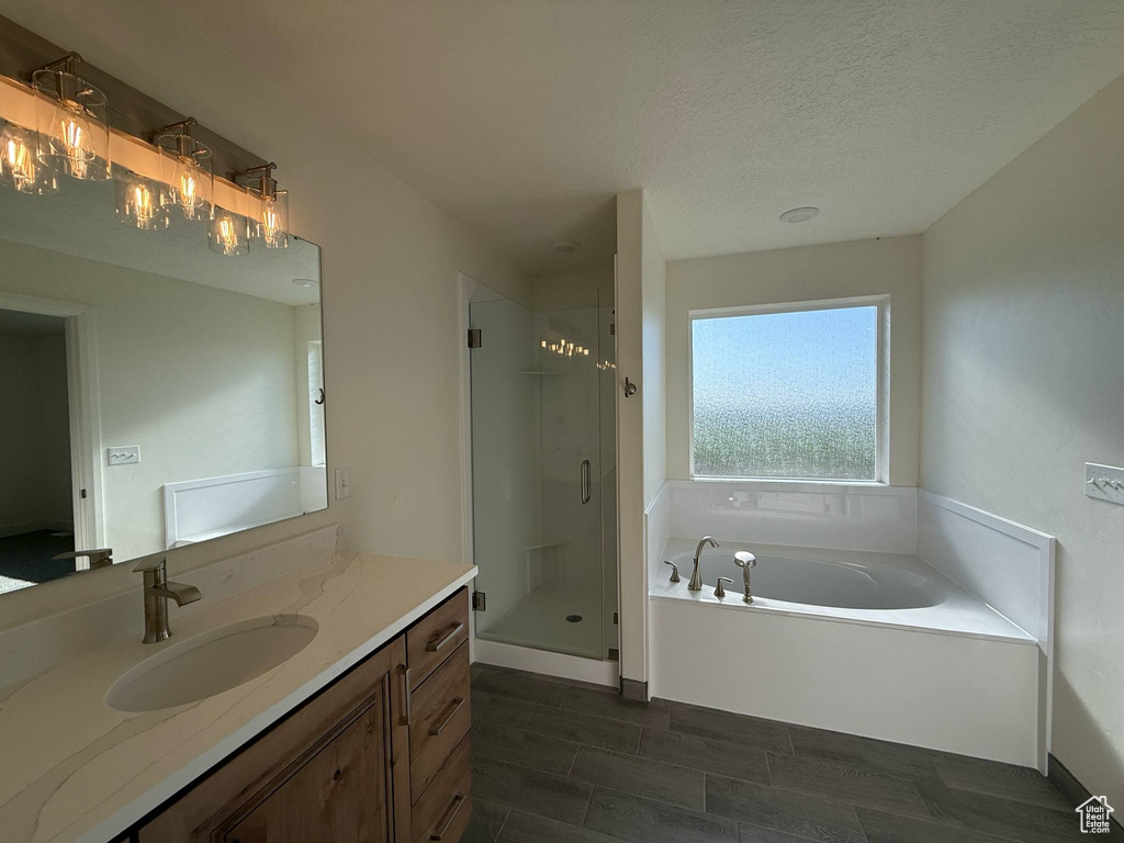 Bathroom with vanity, a garden tub, a stall shower, and a textured ceiling