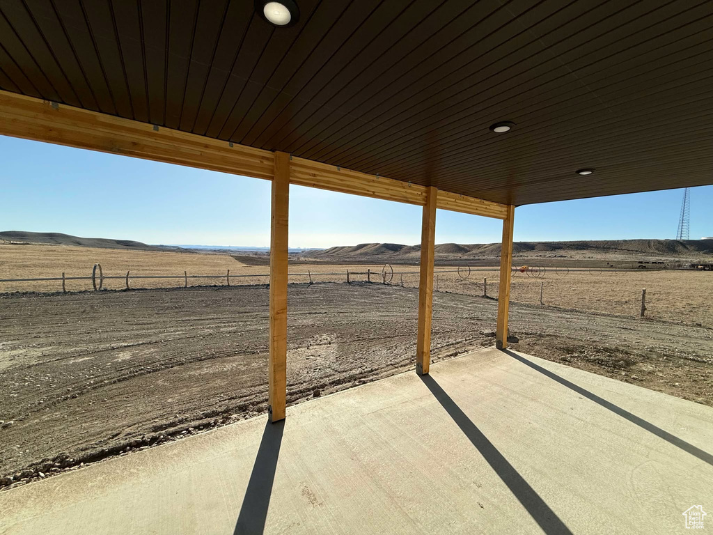 View of patio featuring a rural view, a mountain view, and fence